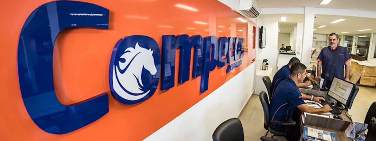 Balcão de atendimento da Compeças Multimarca com equipe atendendo clientes